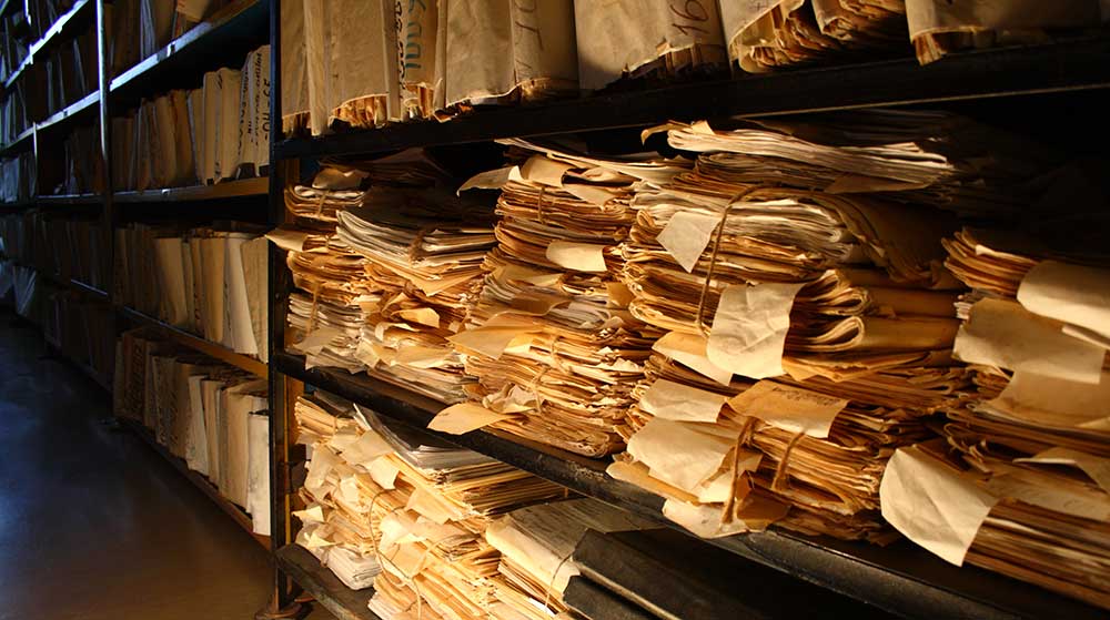 stacks of old papers piled on a shelf-FCRA