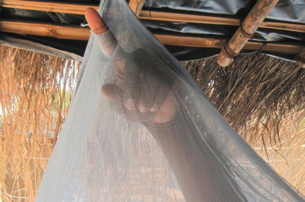 a man poking his finger through a hole in a net