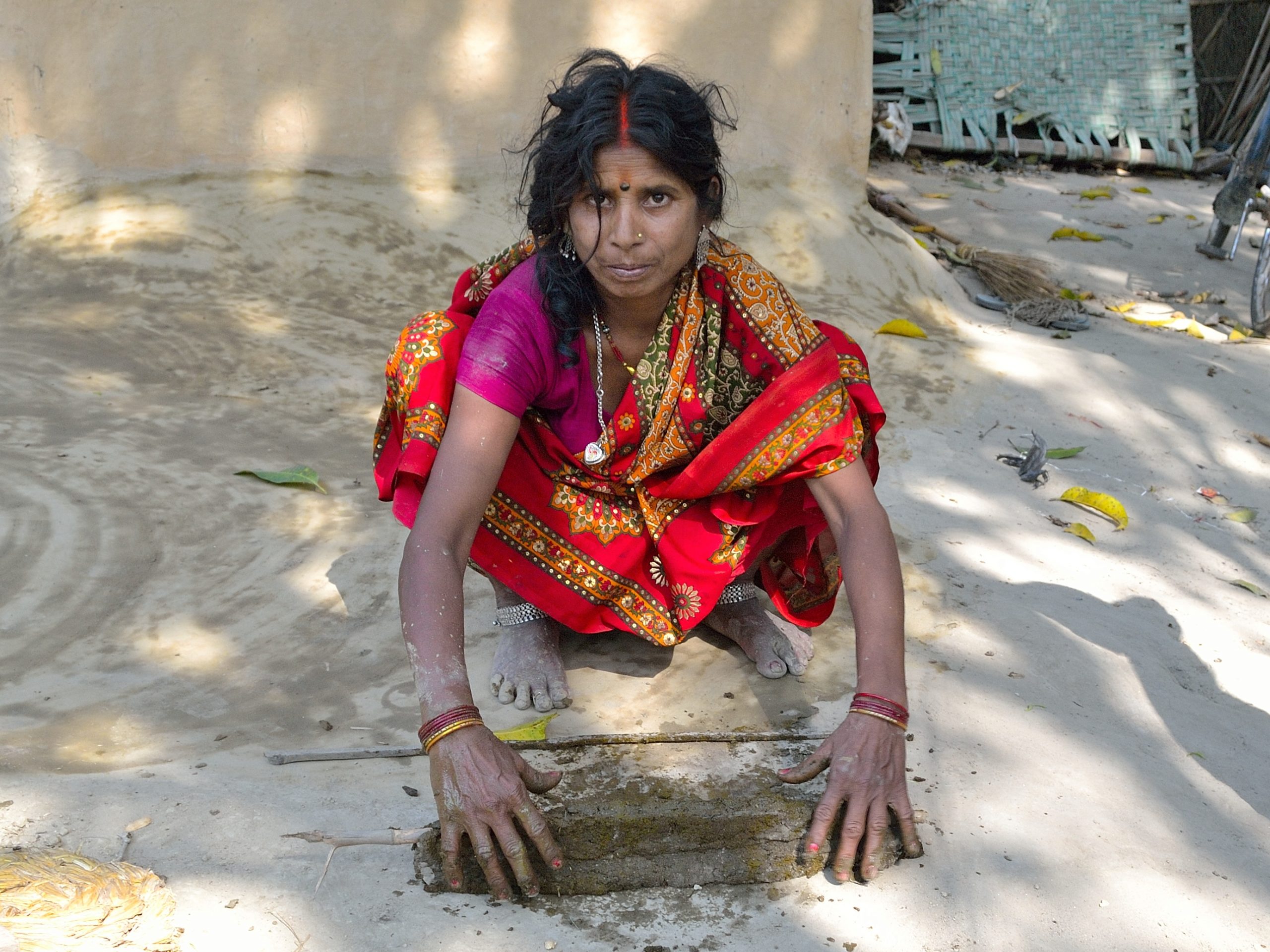 Somen working with manure in a village