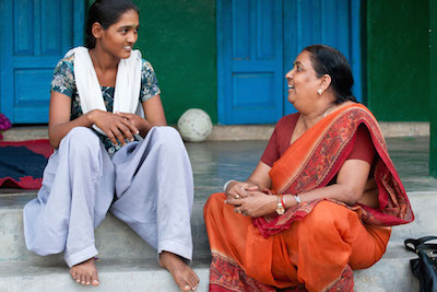 young girl and older woman smiling and chatting