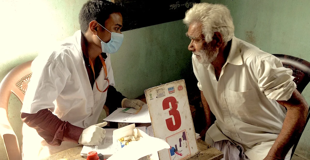 India’s public health system doctor checking a patient