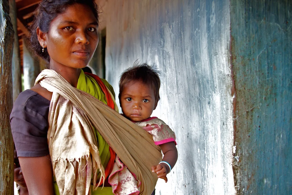 Indian woman carrying infant-maternity benefits