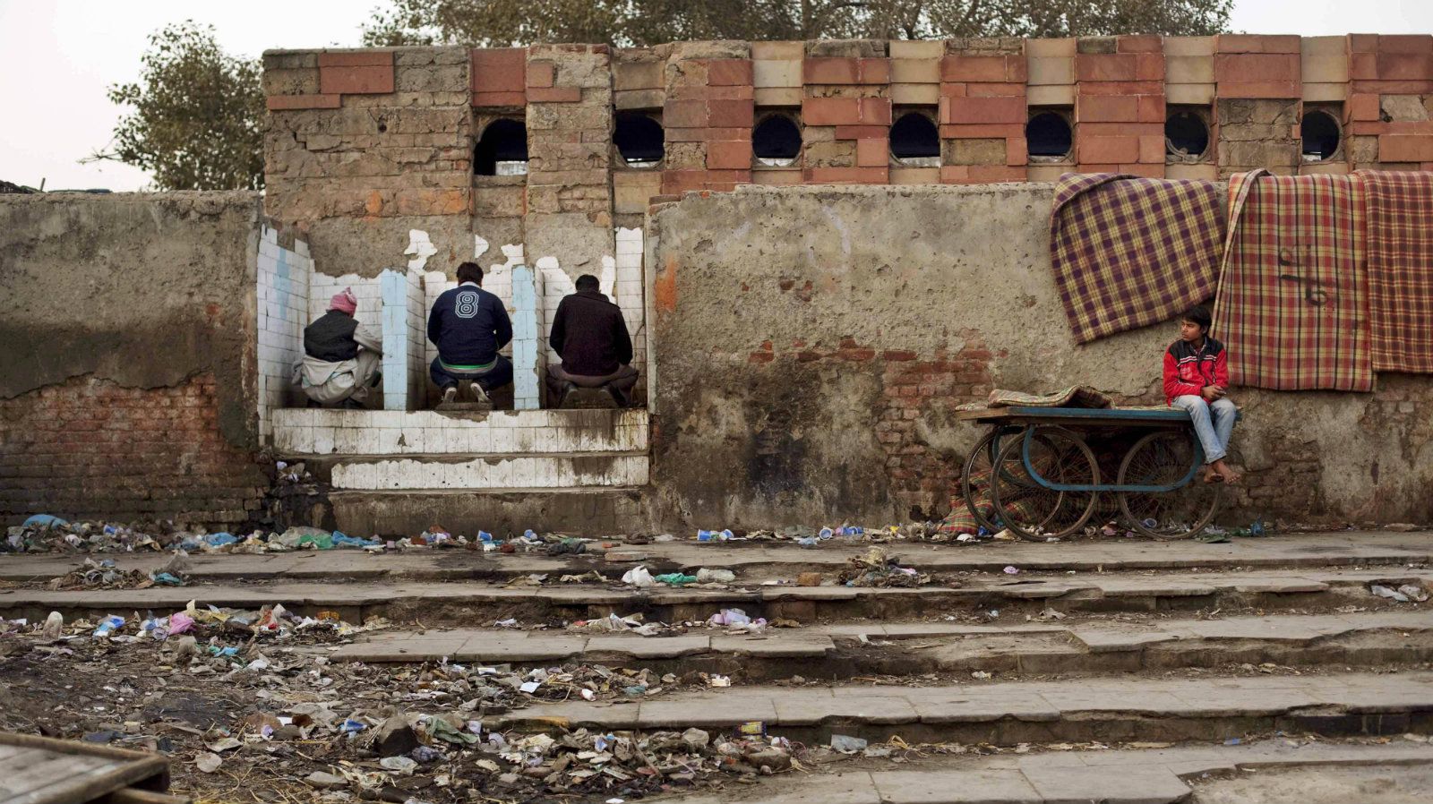 3 men in dirty, open public toilets