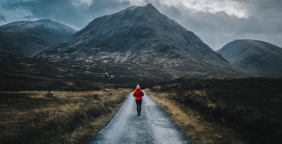 A woman looking up at a mountain