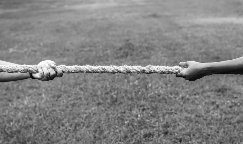 black and white picture of people in a tug of war_rawpixel