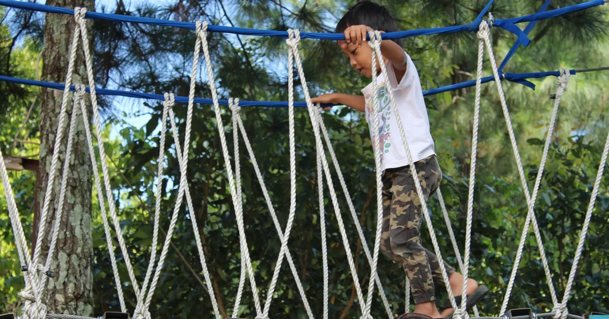 young boy walking on a bridge