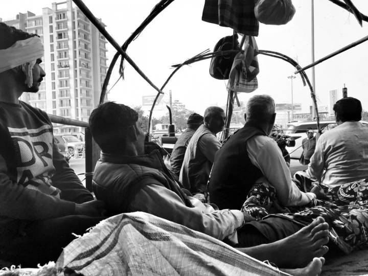 People resting inside a vehicle, looking away from the camera-farmers protest