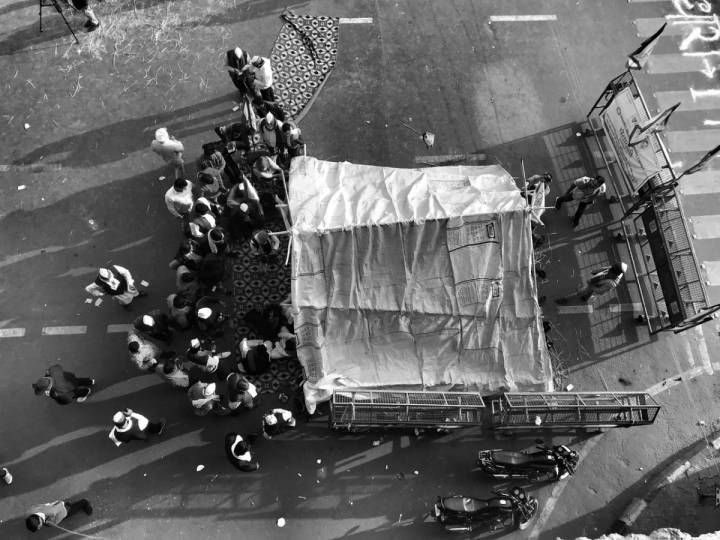 People standing around a tent erected in front of a barricade-farmers protest