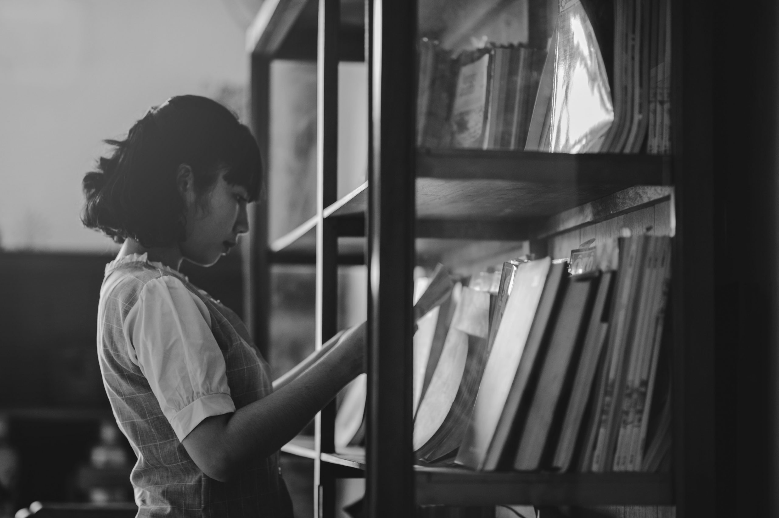 A young girl reading a book in a library