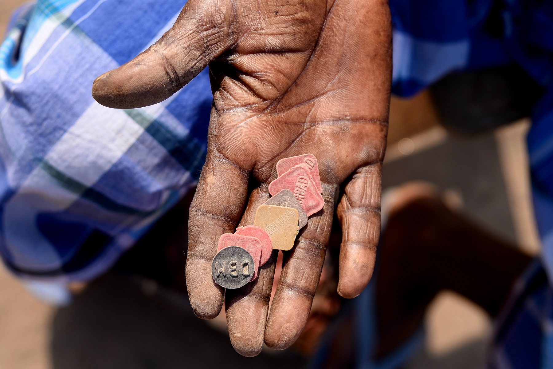 A worker counts tokens—he will get paid at the end of day based on how many of these he has. The workers’ daily wages are based on the number of bricks made or carried.