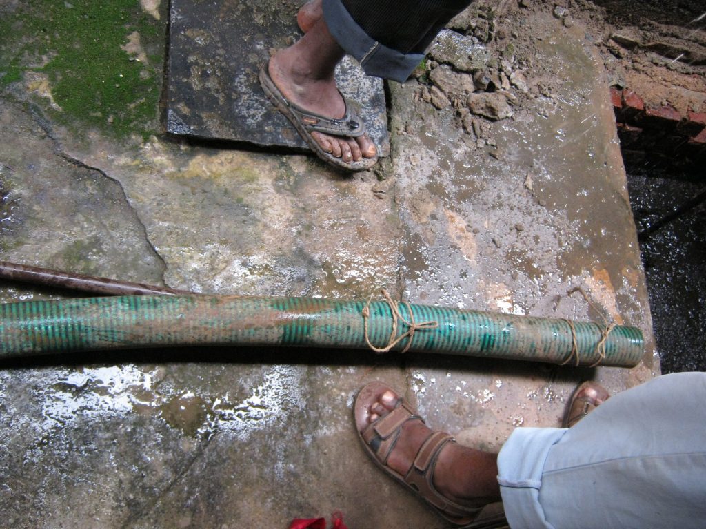 Standing in feacal sludge with bare feet_sanitation workers_epw