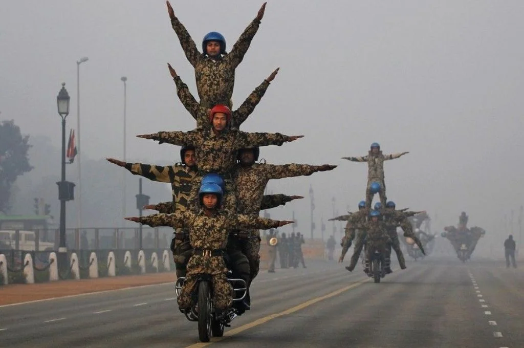 Soldiers performing a stunt on a bike