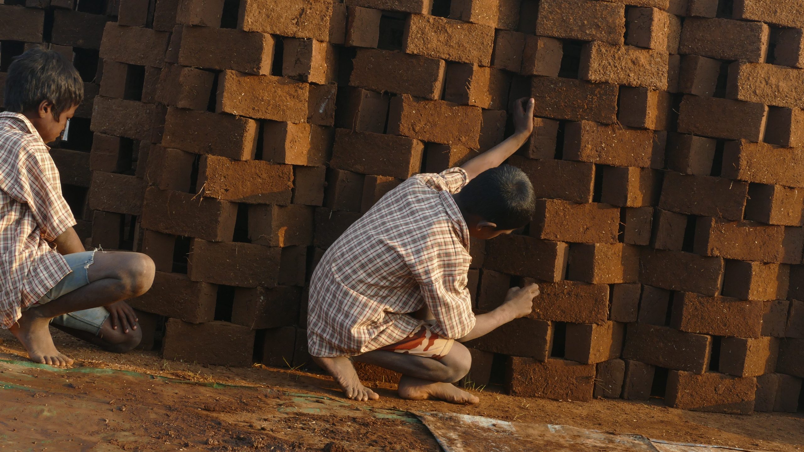 A young boy next to a brick kiln in Sonale, India