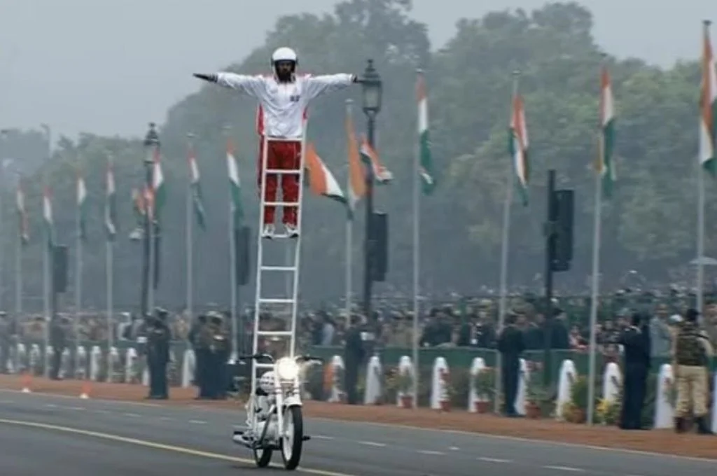 Man standing on ladder on a bike-Republic Day