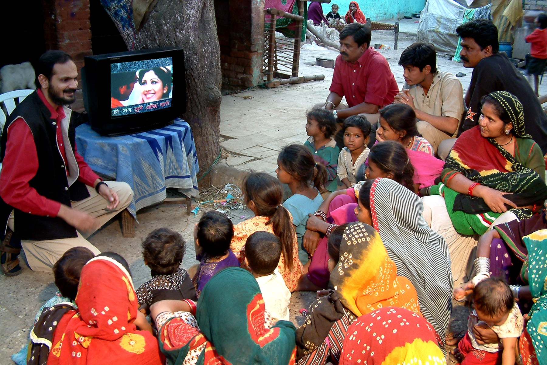 Indian people gathered around a television-entertainment education