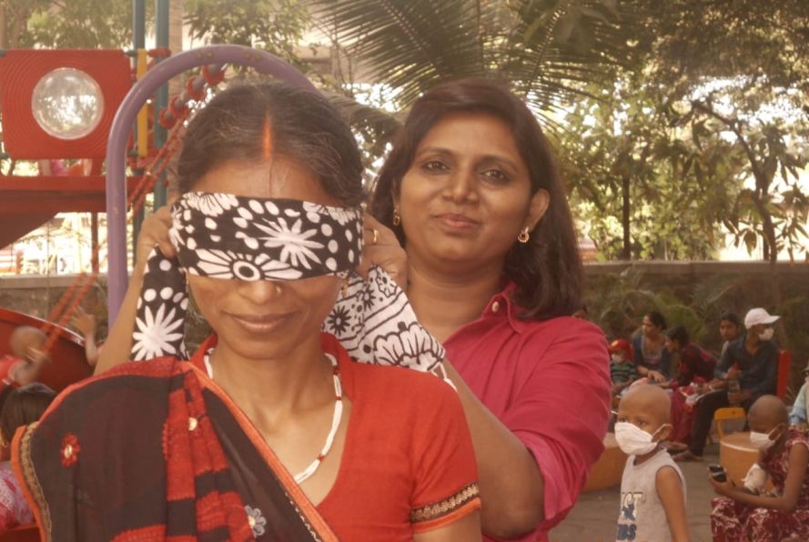 Madhubala blindfolding a mother as part of a game before covid-pediatric cancer