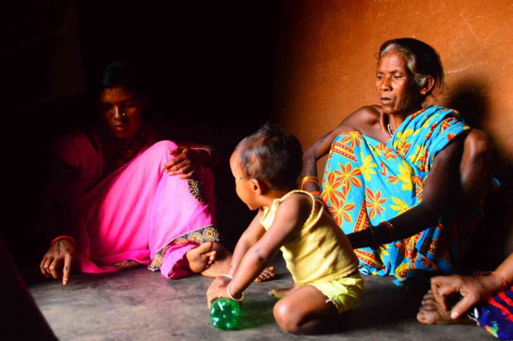 photo3-woman sitting with her family and child playing