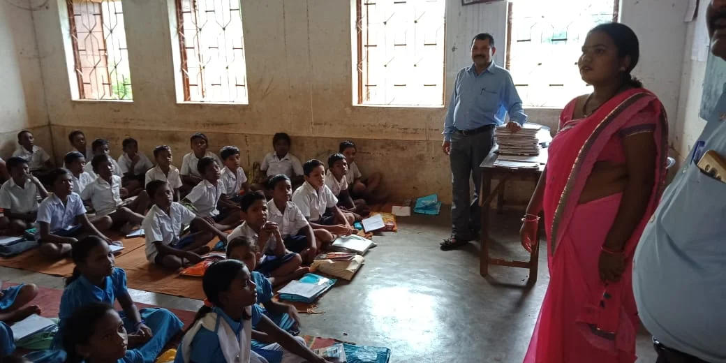 School children sitting on the floor with teachers standing-Panchayati Raj Institutions