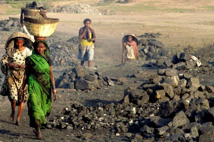 Workers walking through the mine with baskets on their head-coal