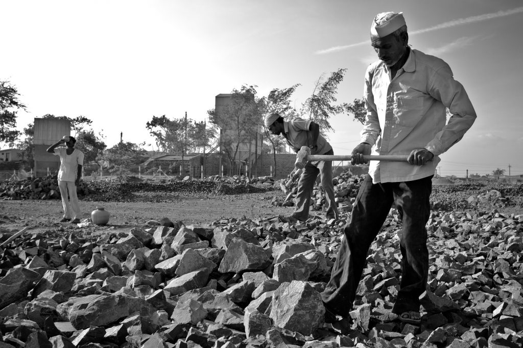 man breaking rocks in India-rural poverty