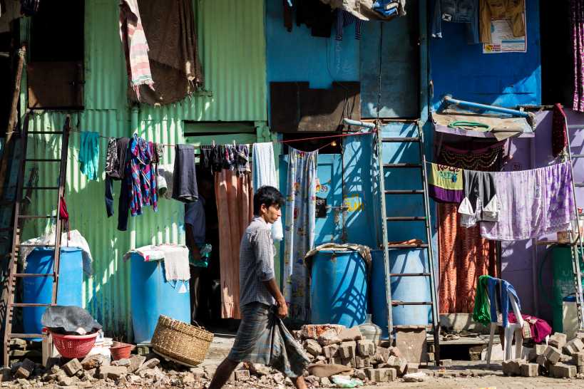 image of a young boy walking past a slum-urban development