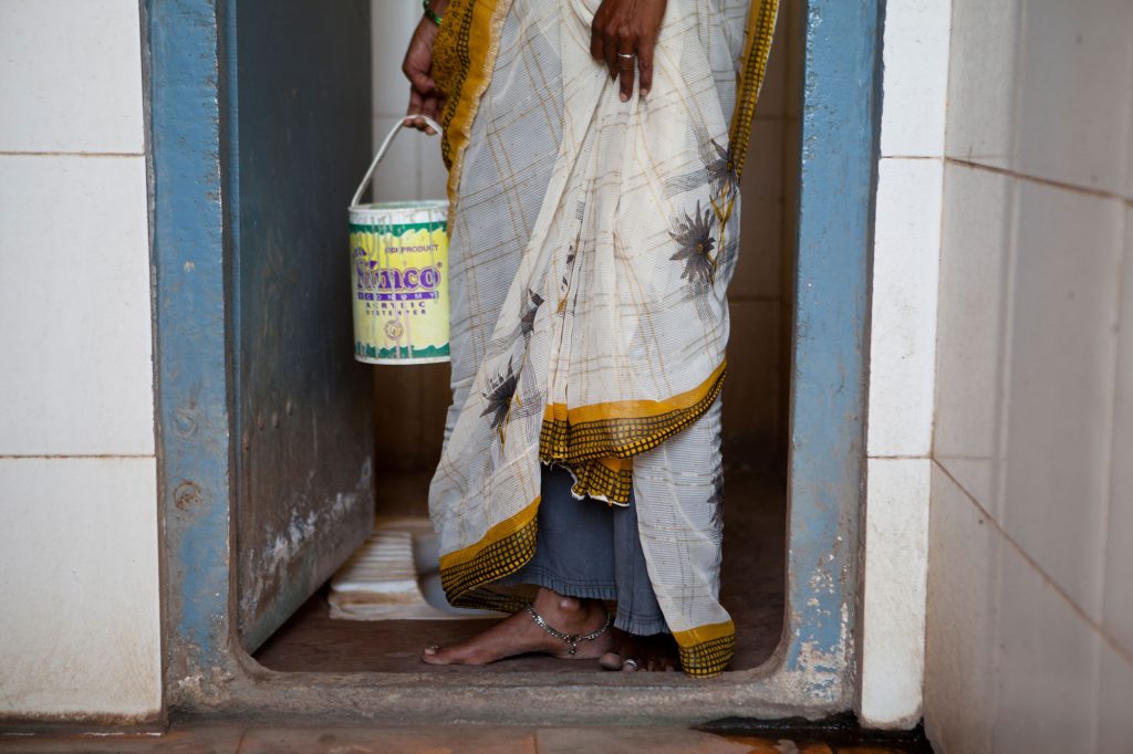 woman holding bucket in toilet-sanitation