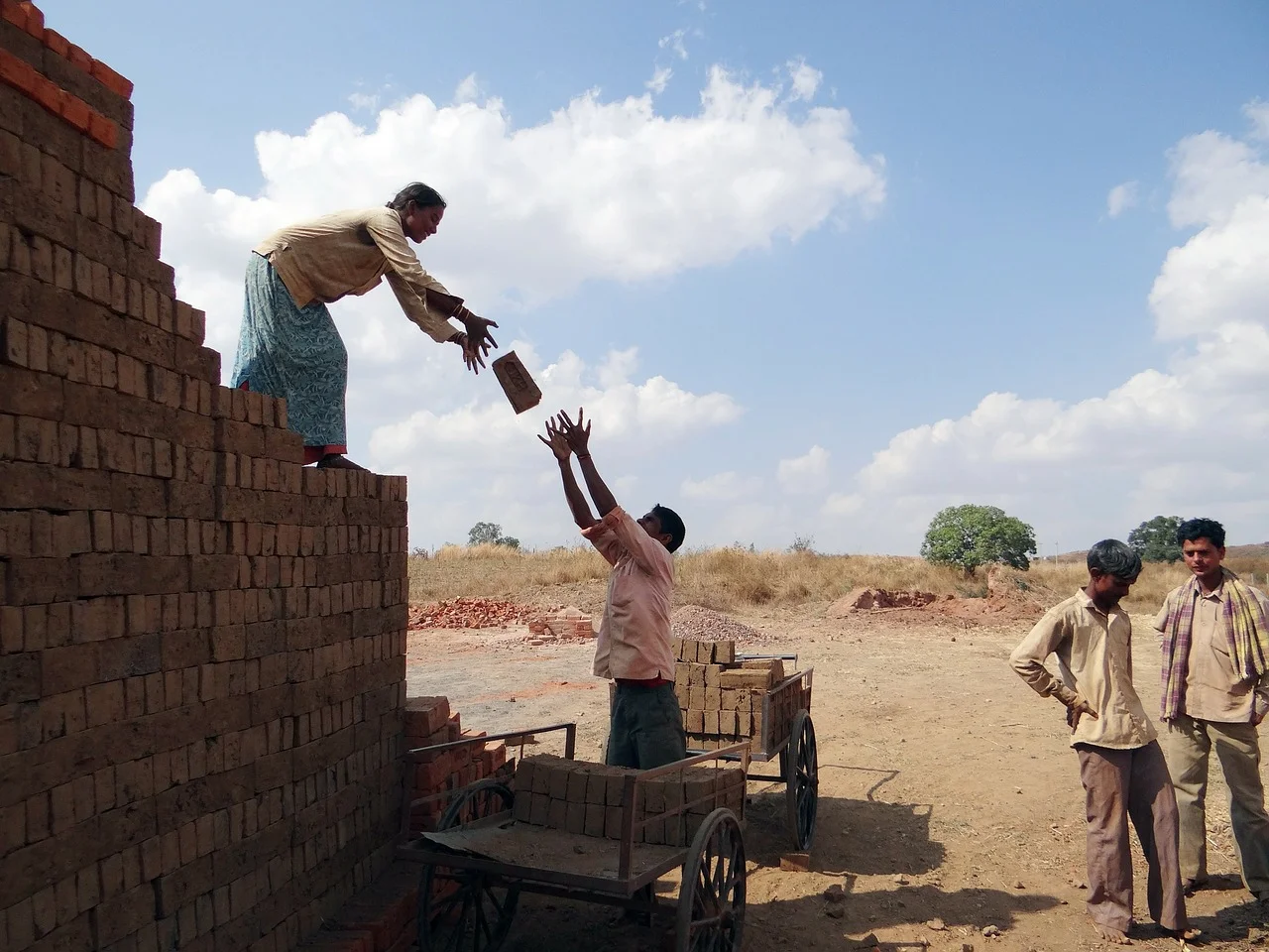 MNREGA workers passing bricks on a construction site