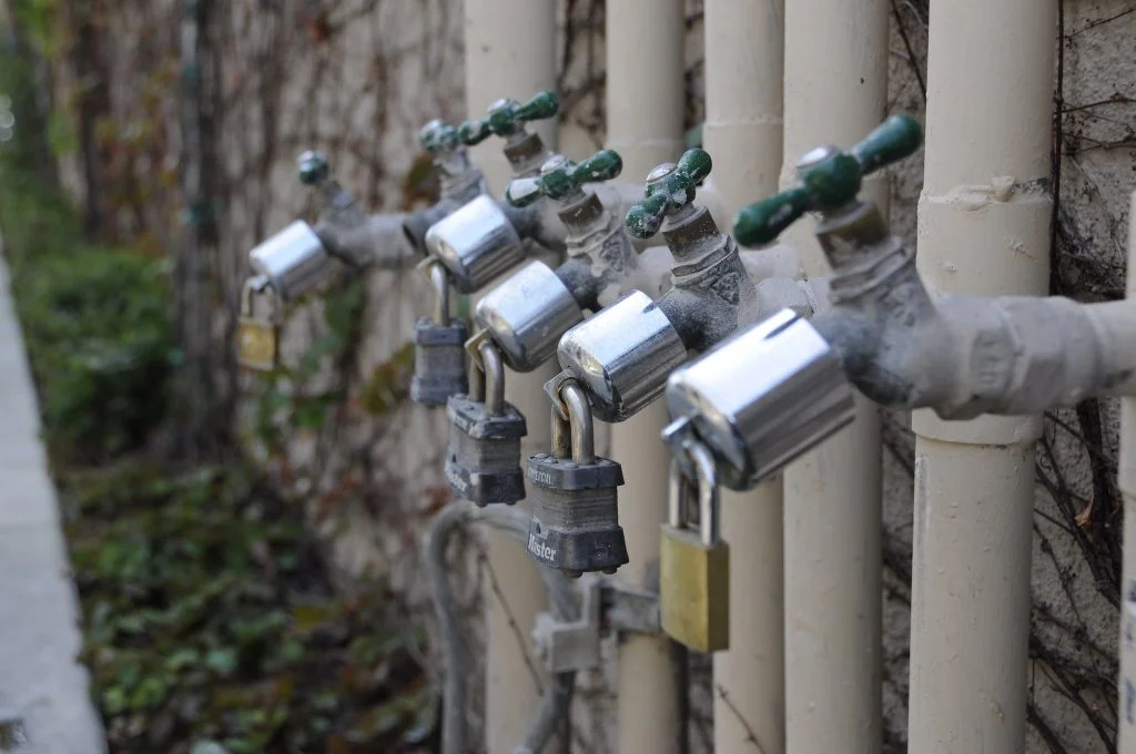 A row of water pipes with locks on theem_philanthropy needs to pay what it takes