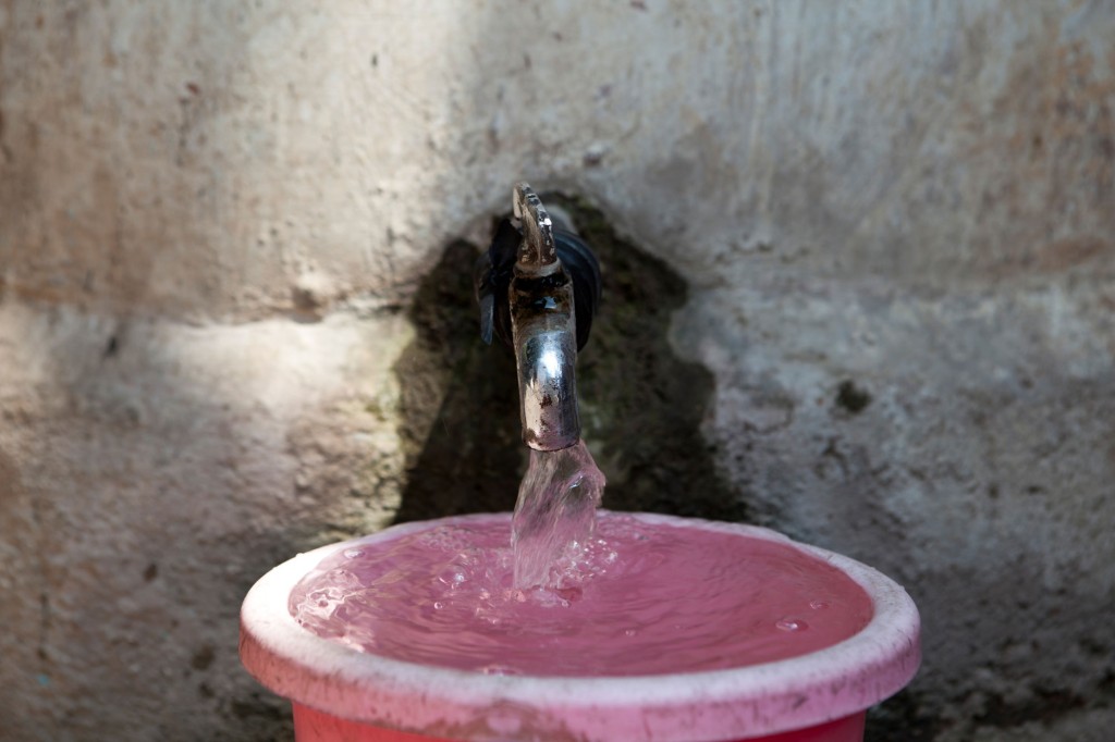 An open tap fills a bucket-SHGs urban sanitation livelihoods