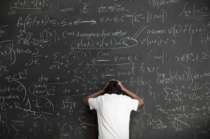 Equations on blackboard with frustrated person trying to solve them-nonprofit