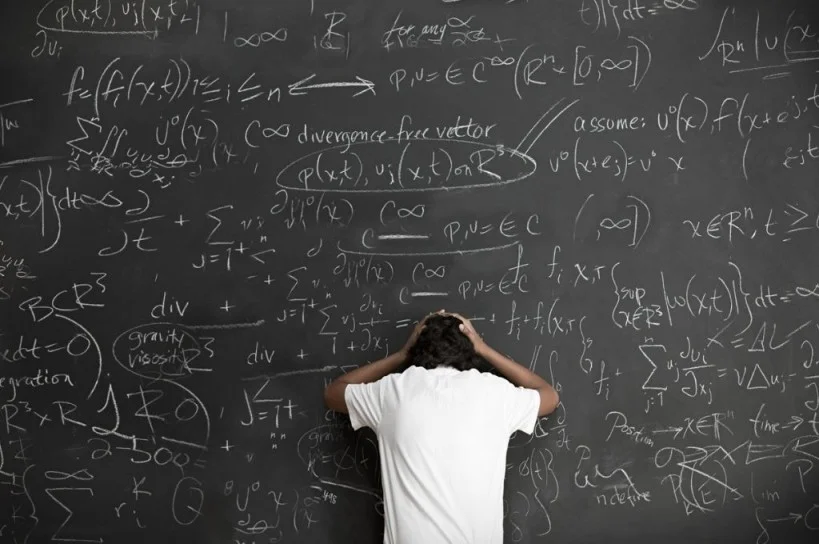 Equations on blackboard with frustrated person trying to solve them-nonprofit