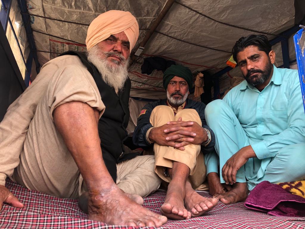Three male farmers sitting at Tikri Border Farm Laws 2020