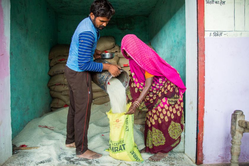 man giving a woman ration PDS-social welfare schemes