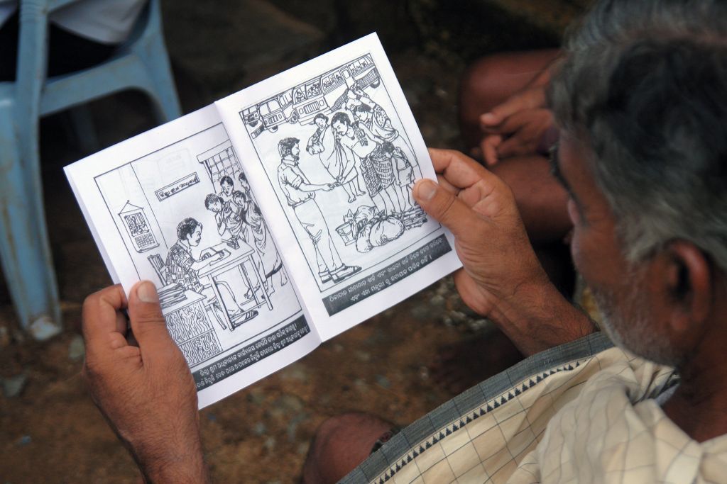 a migrant worker reading a booklet on bonded labour-migrant workers' rights