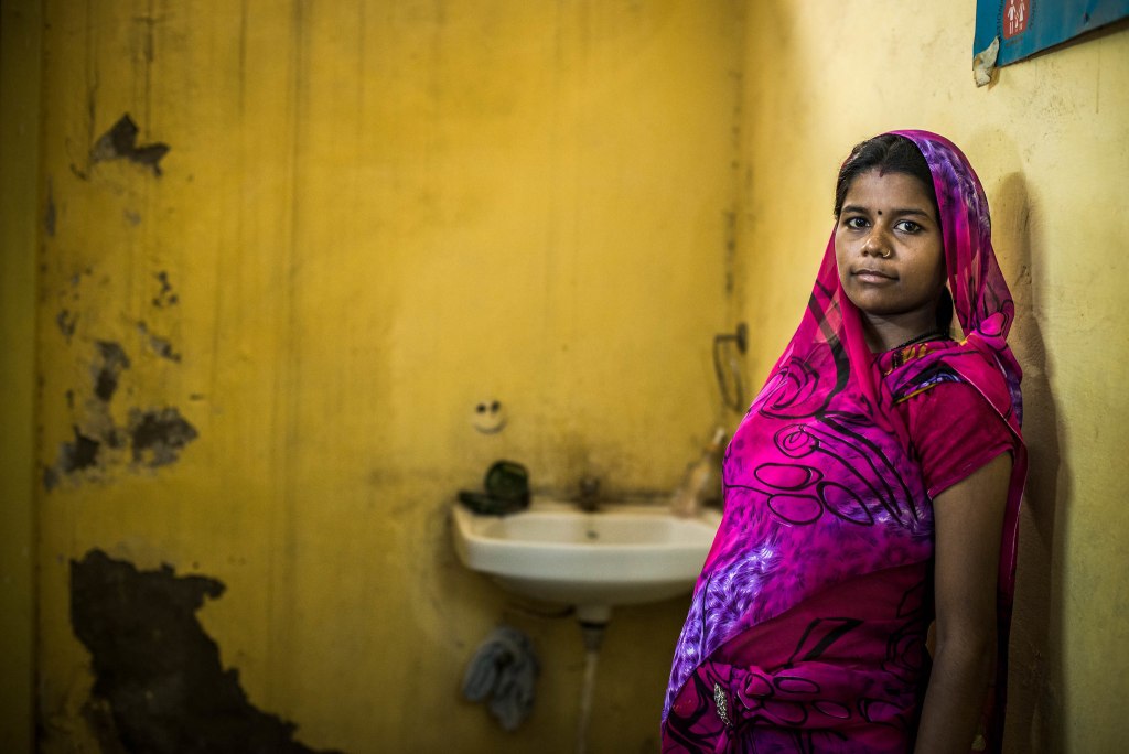 Woman wearing a purple saree standing next to a sink-COVID-19 vaccine pregnant women