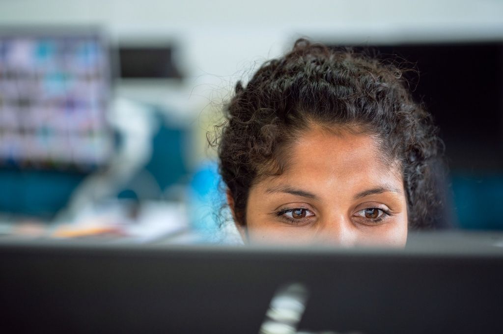 A woman looking at her computer screen in office. As a fundraiser, having a systematic approach to fundraising helps