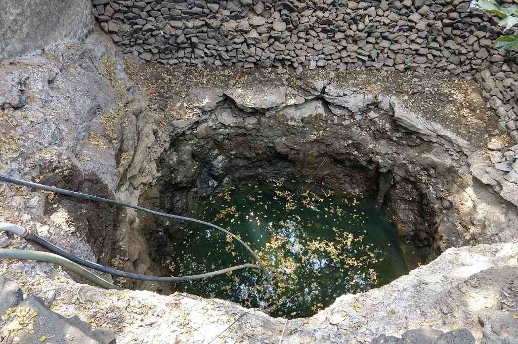 a picture of a stone well with water in it-