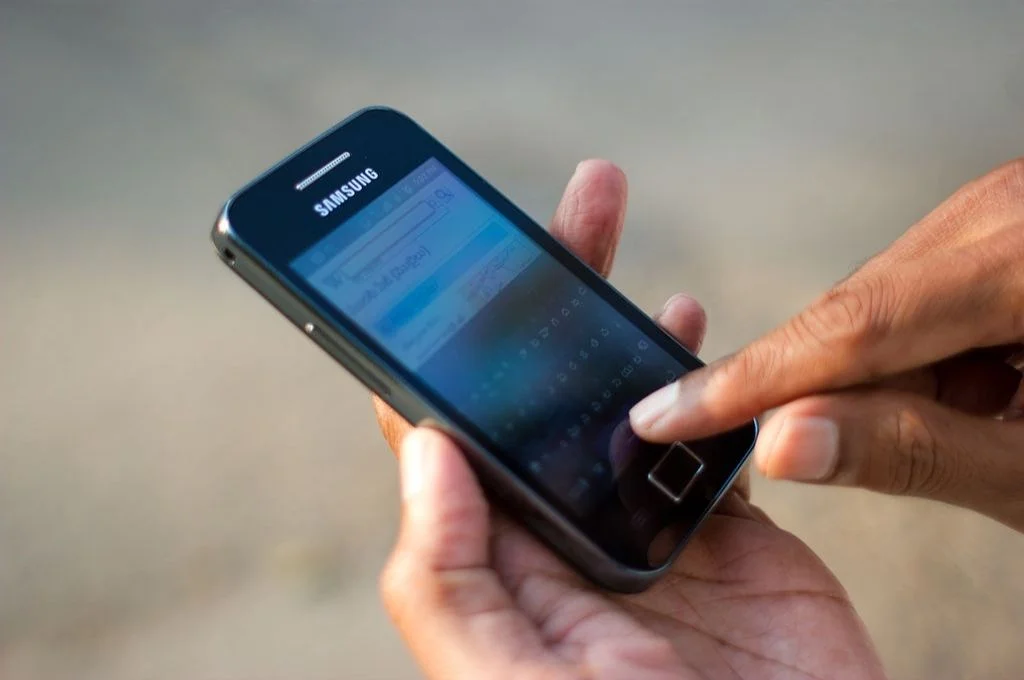 image of a phone in the hands of someone attempting to type-technology for nonprofits