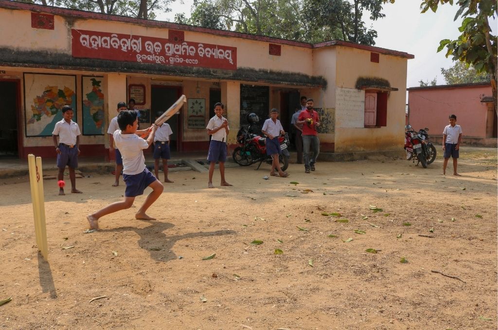 A boy playing cricket outside a school in Odisha Gram Vikas Ajaya Behera-National Assessment Survey-ASER
