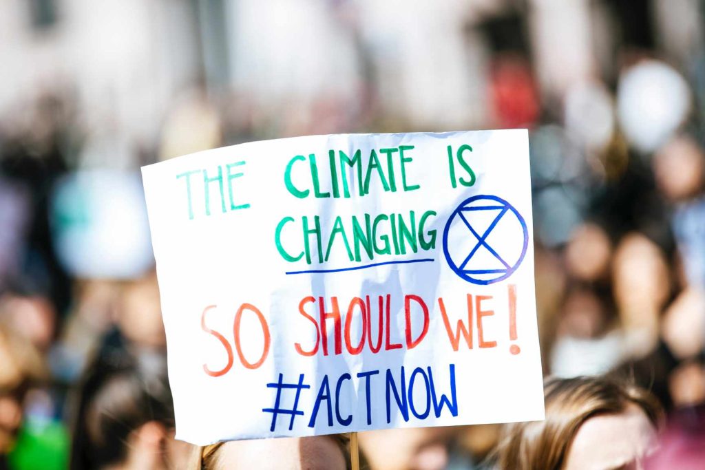 climate change protest sign saying the climate is changing so should we, act now at COP 26