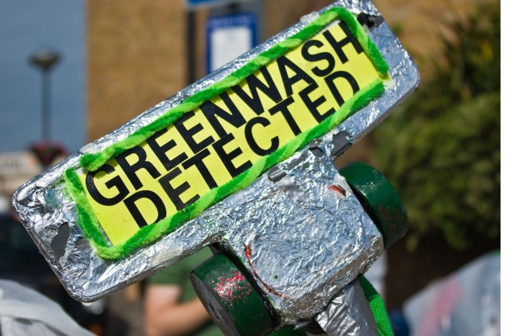 A banner at a protest that says Greenwash detected-COP 26-exclusion