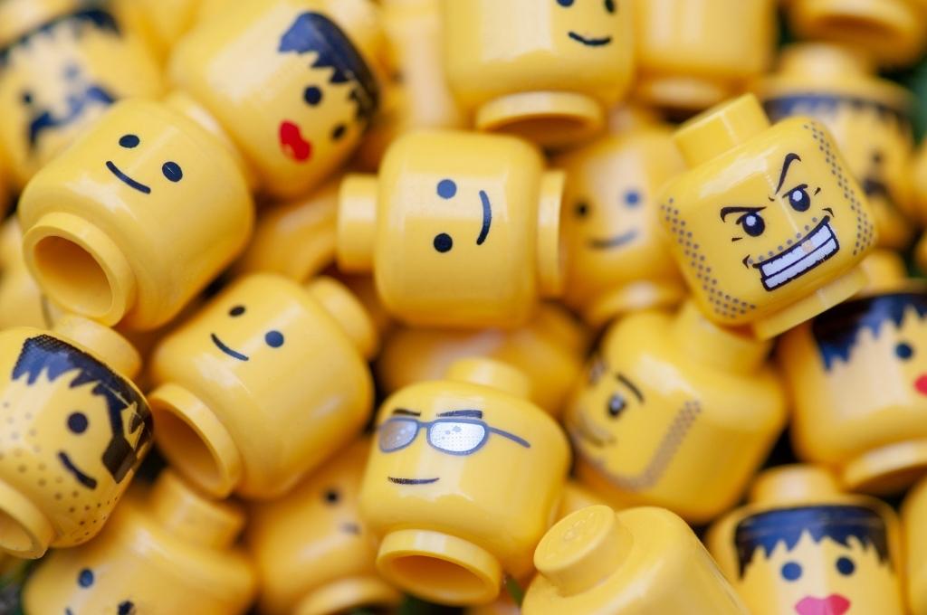 close up of yellow lego with different heads, with different faces and expressions, all together-nonprofit humour