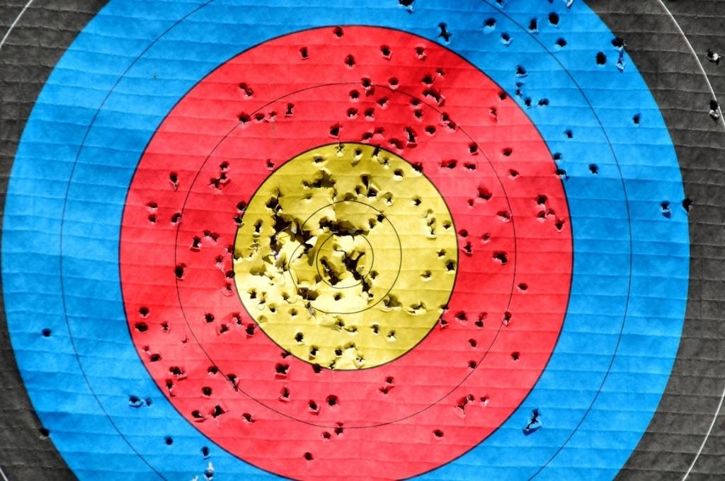 an image of a target board with concentric circles of yellow, red, blue, and black from the inside out. There are holes all across the target board-social emotional learning