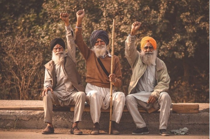 Three farmers at the India farmers' protests with their hands raised_Ravan Khosa_Wikimedia Commons-collective