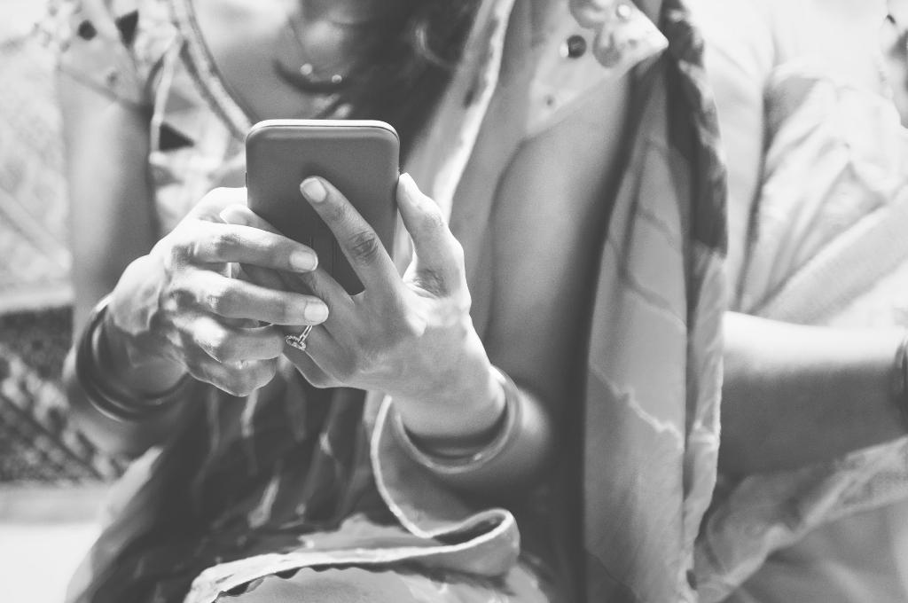 close up of indian woman using mobile phone in black and white-open source technology