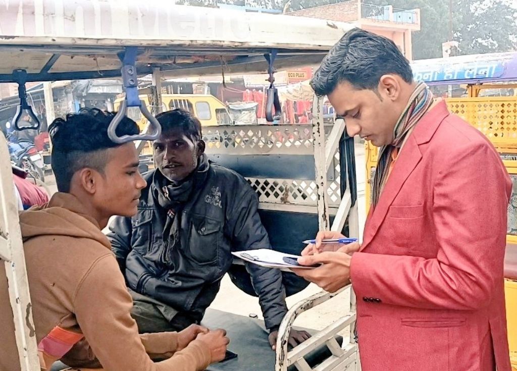 A journalist with a notebook in hand speaking with two men in an auto