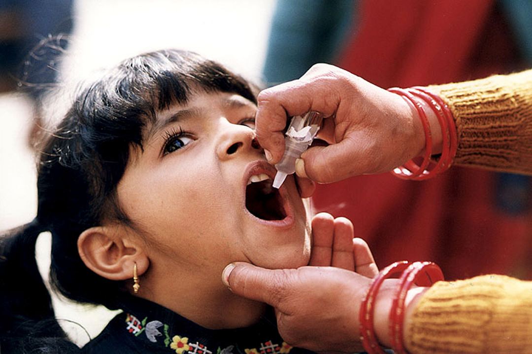 A young Indian girl receiving a dose of the polio oral vaccine