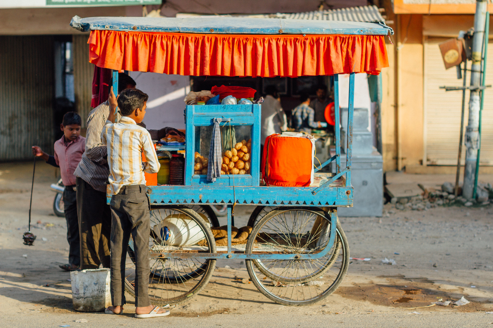 a street vendor selling paani puri on a blue cart - street vendors act