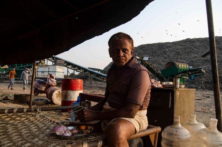 An informal worker at the Ghazipur landfill near New Delhi prepares a meal-waste management