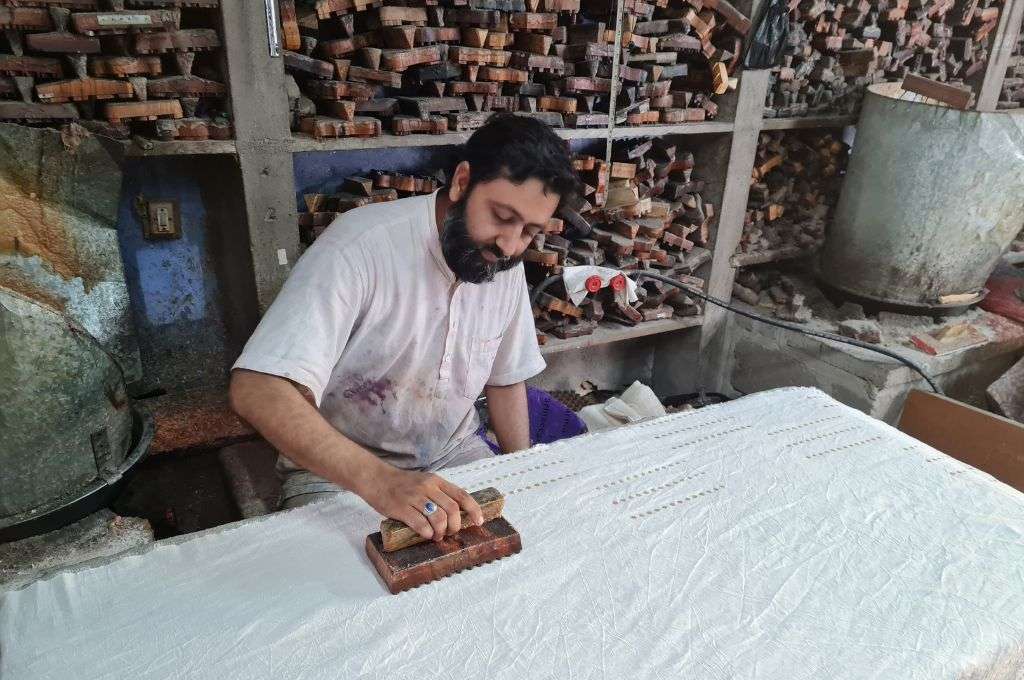 Shakil Khatri, a batik artisan uses a handblock to print on fabric-batik Kutch